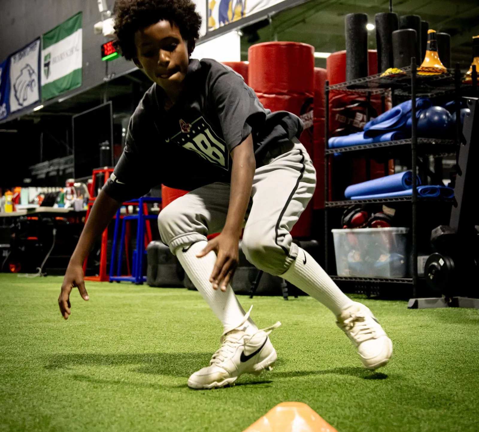 Young HAUS athlete cutting around a cone on turf