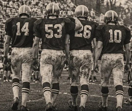 Archival photograph of football players walking off the field